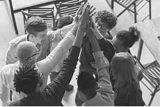 Team joining hands to celebrate success and unity